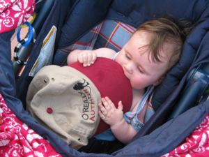 A photograph of six-month-old Carolyn chewing on the rim of her father's "O'Reilly Author" baseball cap.